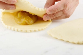 Folding and sealing the puff pastry around the apple compote is the step that gives your turnovers their final shape..