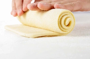 The art of rolling and slicing the brioche dough is what gives the final loaf its signature layers and soft, fluffy texture