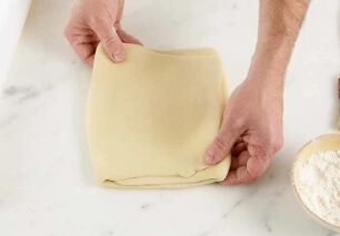 "Placing the laminated butter square onto the center of the chilled croissant dough