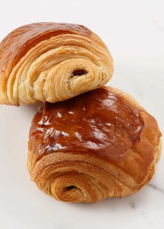 Golden and flaky homemade pain au chocolat with layers of buttery pastry and melted chocolate.