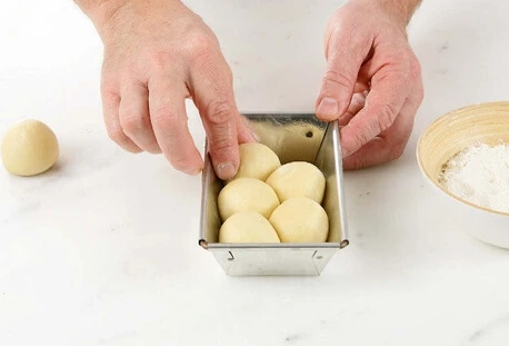 Brioche dough brushed with egg wash and proofing in a warm environment.
