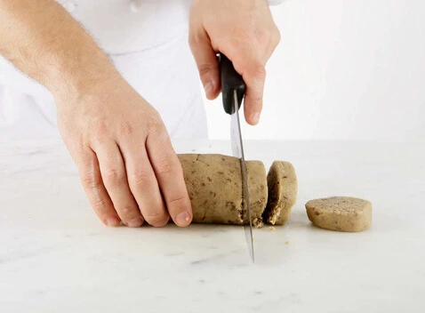 Un pinceau appliquant un egg wash sur une pâte, créant une finition dorée et brillante.