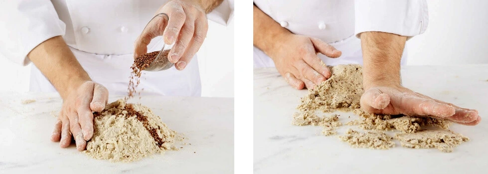 A close-up of flax seeds being sprinkled into dough, adding texture and nutrition to the mix.