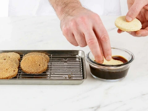 A saucepan with dark coffee soaking syrup being gently heated on the stove