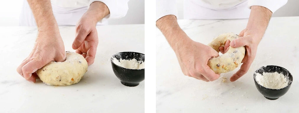 Hands delicately folding risen dough on a floured surface to gently release gas without tearing the gluten structure.