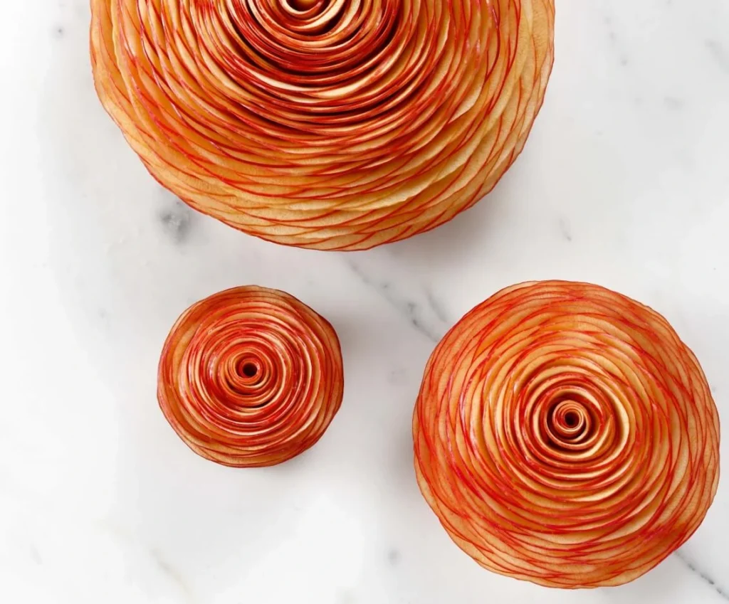 Elegant apple tart by Cédric Grolet, shaped like a rose with paper-thin apple slices glazed in browned butter