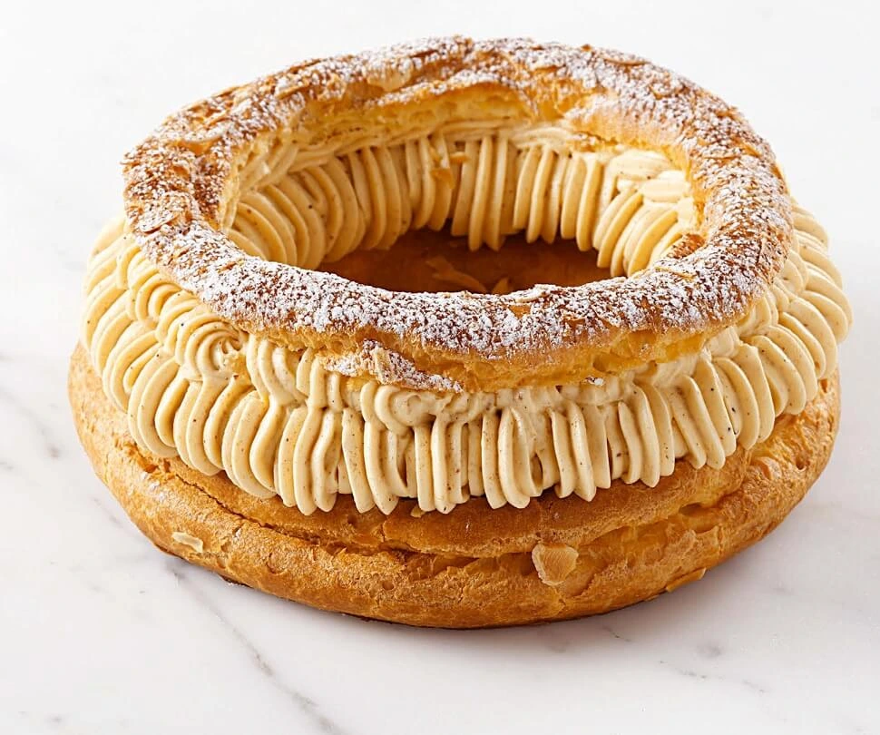 Close-up of a traditional Paris-Brest pastry, filled with praline mousseline cream and dusted with icing sugar