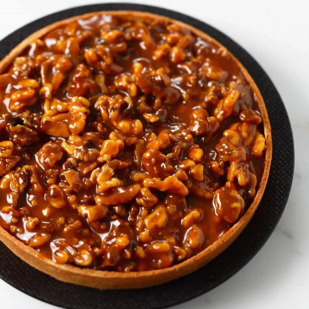 A golden-brown nut tart with a delicate, buttery crust and a glossy, caramelized nut filling.