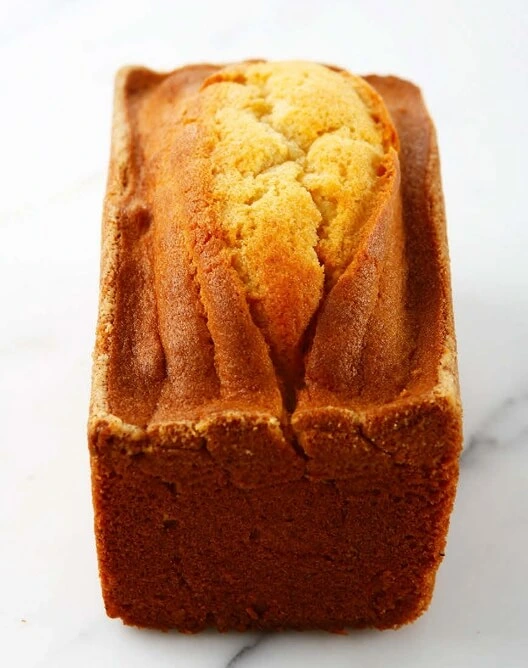 Tranches de cake quatre-quarts moelleuses et dorées, avec une coupe nette, sur une assiette élégante