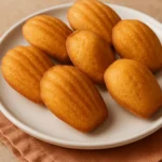 Golden, perfectly risen madeleines with a classic shell shape, ready to be enjoyed